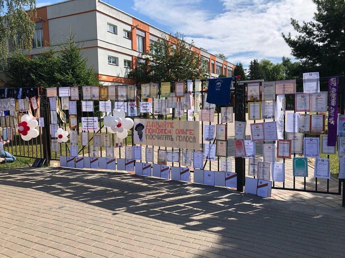 Люди несут свои грамоты, медали, цветы и венки к школам и гимназиям, где были избирательные участки Люди несут свои грамоты, медали, цветы и венки к школам и гимназиям, где были избирательные участки